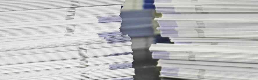 Piles of handout papers lying on a table.